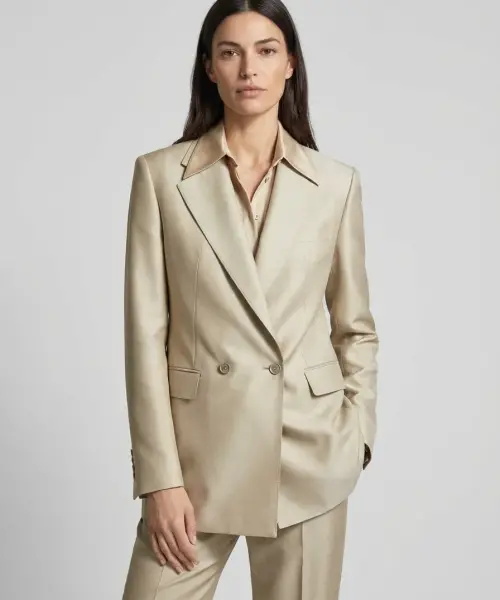Ensemble beige Pure Élégance avec veste croisée à boutons et pantalon assorti, porté avec chemise claire.