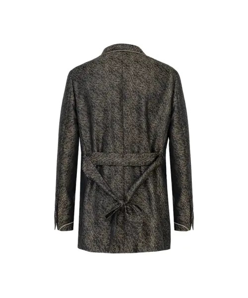 Veste longue Pure Élégance en brocart noir et or avec liserés clairs, chemise blanche plissée et pantalon noir.