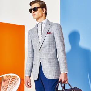 Tenue homme PureElegance avec veste grise à carreaux, chemise blanche, cravate grise rayée, pochette bordeaux et pantalon bleu.