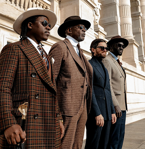 PureElegance : groupe d’hommes en costumes sur mesure avec coupes structurées, matières texturées et motifs (carreaux/tons neutres), style élégant et affirmé.